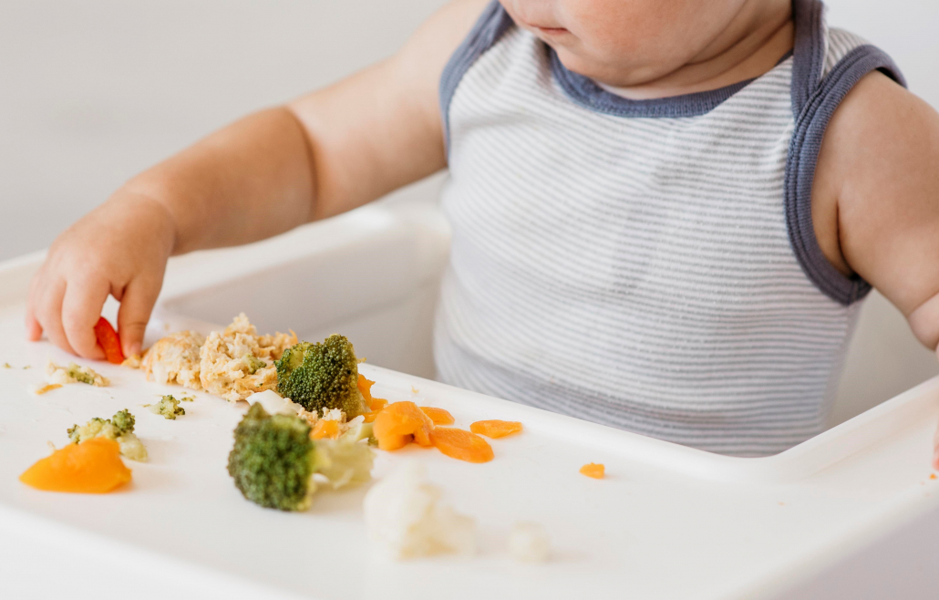 cute-baby-boy-in-highchair-choosing-what-to-eat